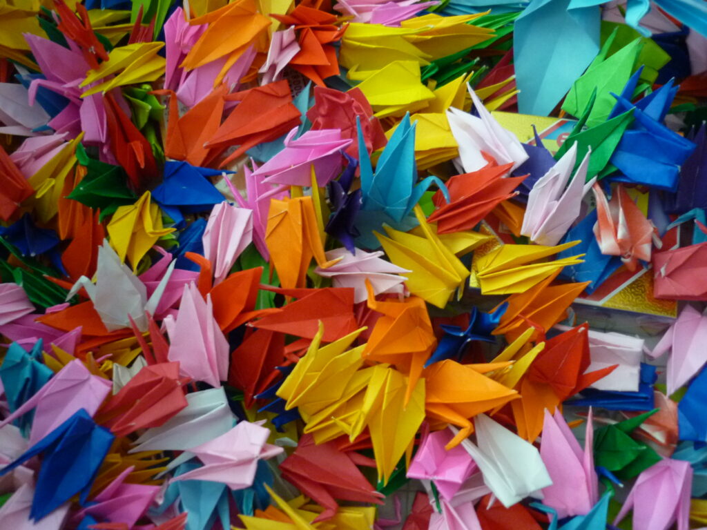 Accumulation d'origamis colorés en forme de grues
